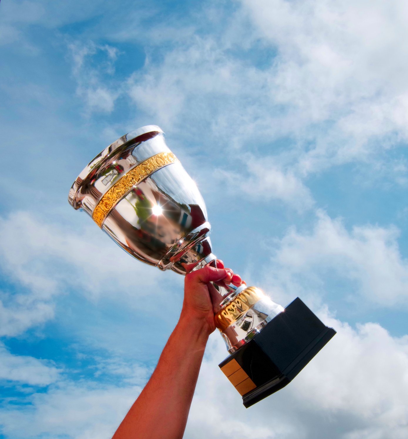 The winner takes it all. Champion winner trophy cup on sky background.